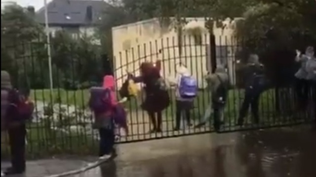 Из-за лужи у входа в калининградскую школу №8 ученики лезут на забор (видео)
