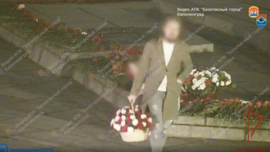 Мужчина уносит с мемориала корзину с цветами | Скриншот видеозаписи с камер «Безопасного города»