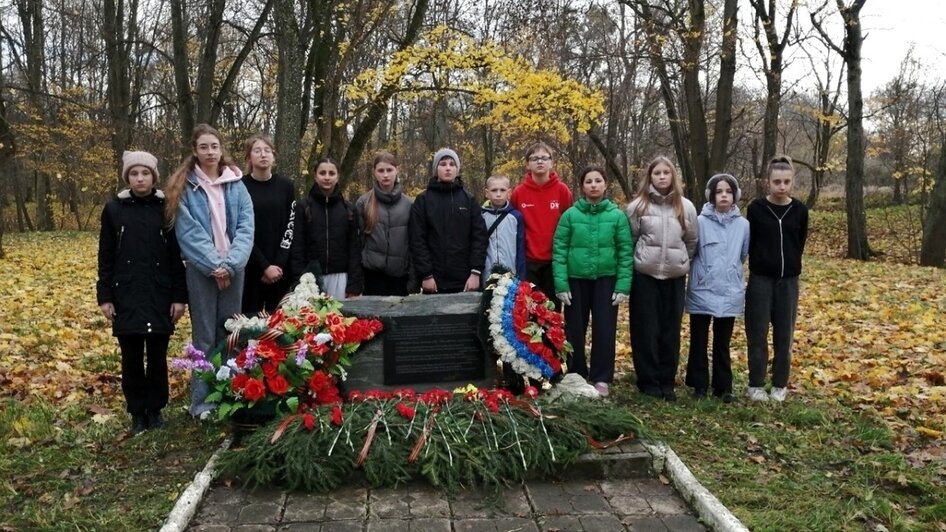 Черняховский р-н, пос. Красная горка. Памятник на могиле радистки разведгруппы «Док» Тамары Васильевой. Ребята из объединения «Наш край»