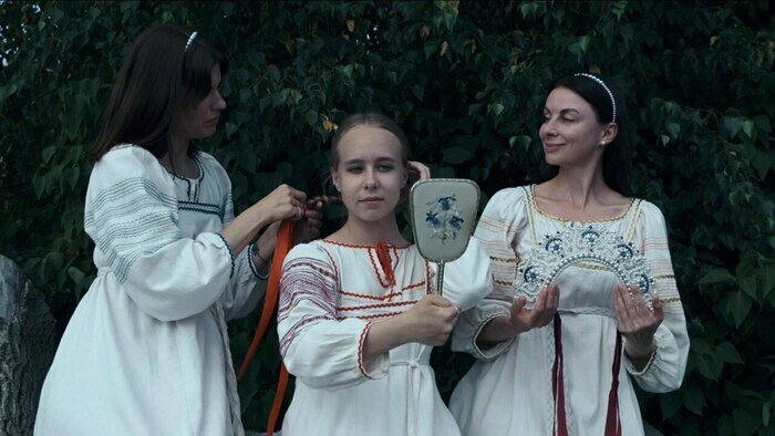 Руководитель фольклорного ансамбля «Летавица» Татьяна Федотова заплетает косу своей ученице Кристине Татур | Фото: архив героя публикации