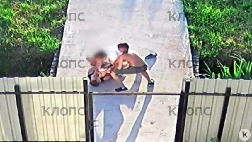 Женщина навалилась на мальчика и держит за футболку, её пытается оттащить старший брат  | Скриншот видеозаписи 