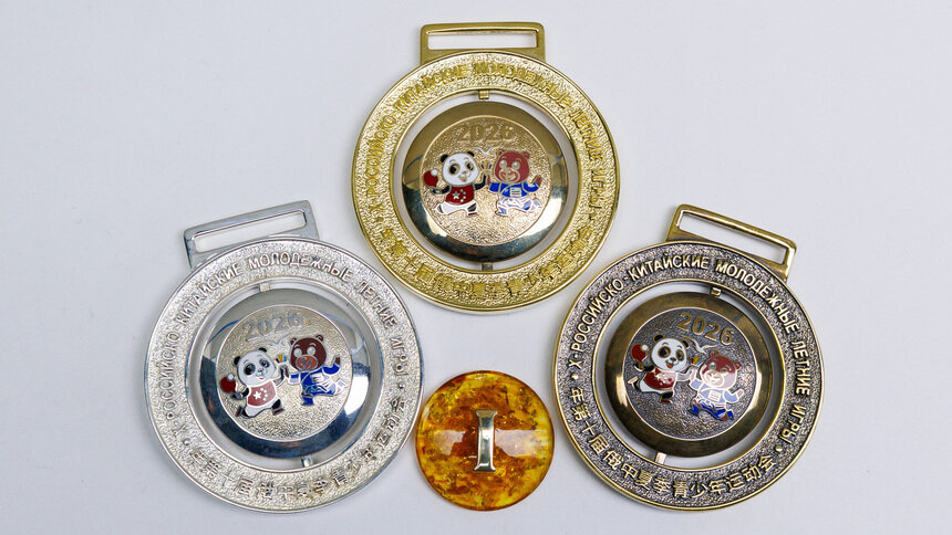 Несколько образцов медалей  готовы. Два медведя – бурый из России и панда из Китая – с одной стороны, и янтарный вкладыш с указанием места – с другой | Фото: Александр Мелехов 